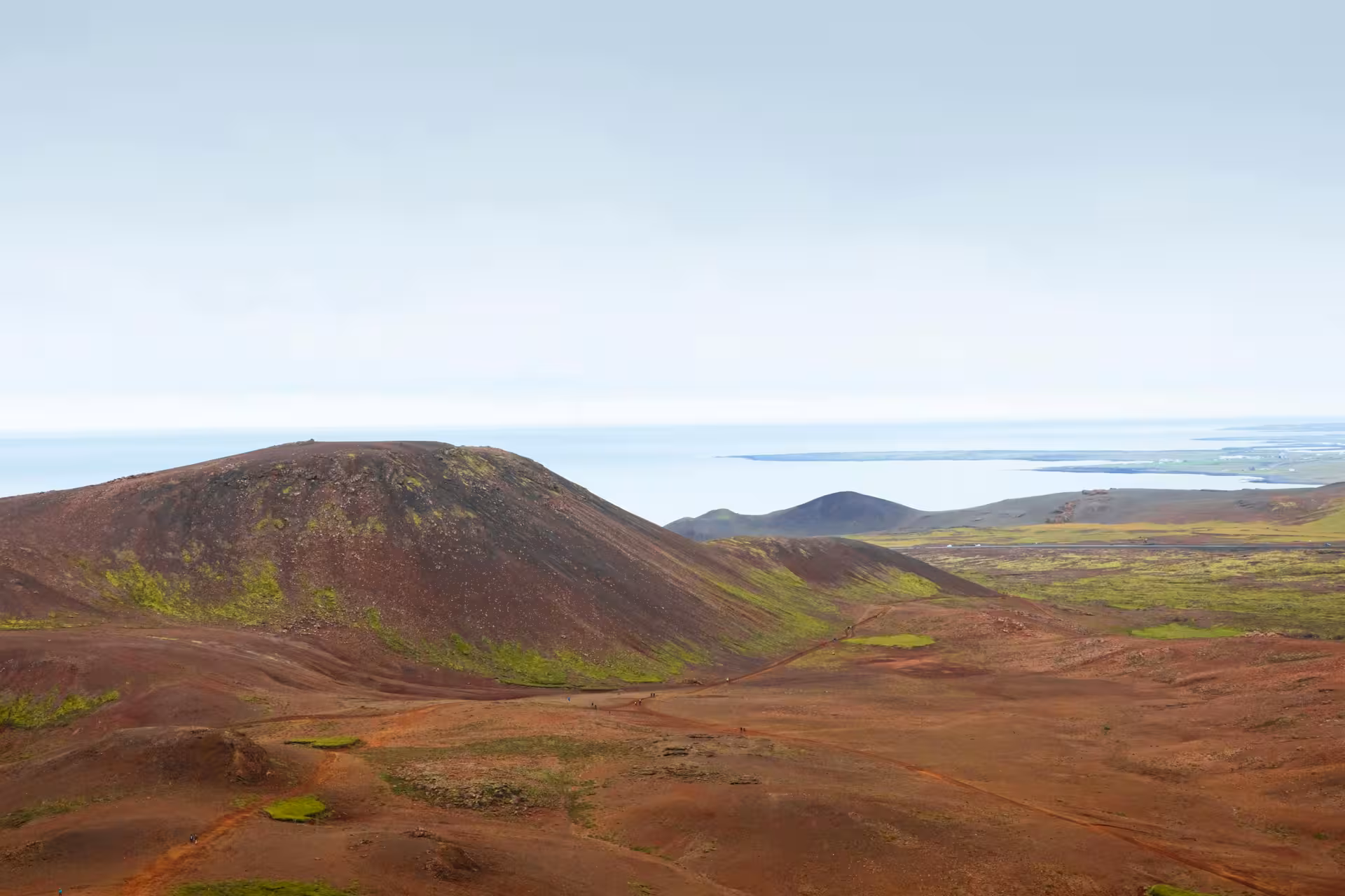 Red volcanic craters and green moss on Reykjanes Peninsula with ocean views in Iceland