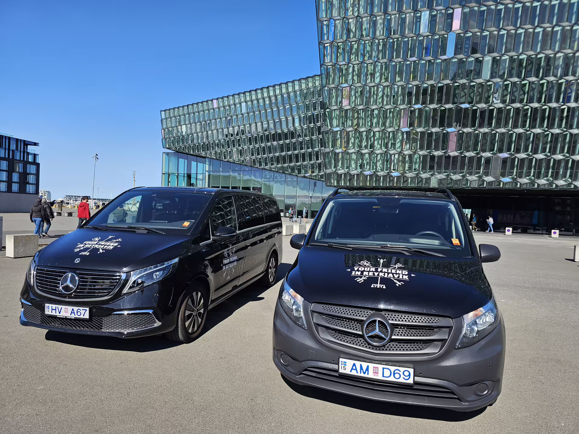 Two two vehicles parked with the "Your Friend in Reykjavik" logo on the hood of the car. 
