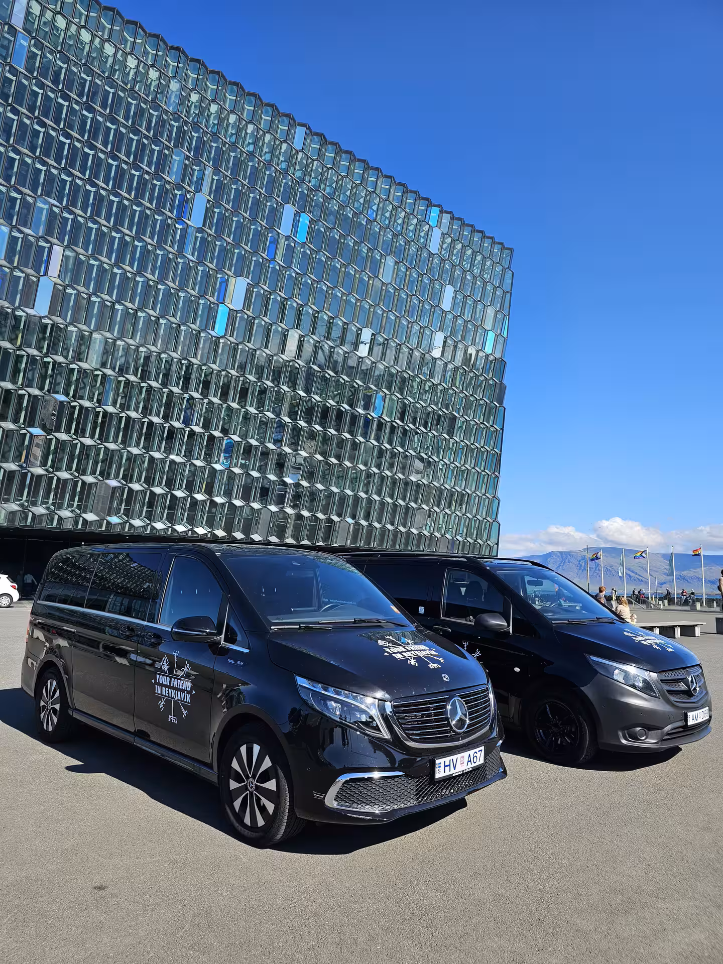 Two Tour Vehicles from Your Friend in Reykjavik parked in front of the Harpa Concert Hall in Reykjavik