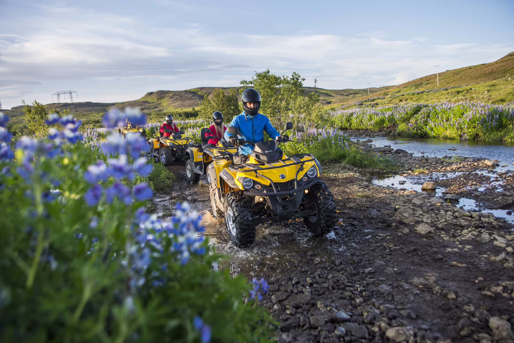 Adventurers ride yellow ATVs through lush Icelandic landscapes near Reykjavik, showcasing the thrill of the 1-hour peak tour.