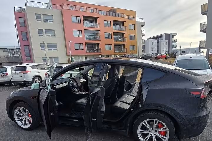 Modern car parked near colorful buildings, ideal for private transfer from Reykjavik to Blue Lagoon with comfort and style.