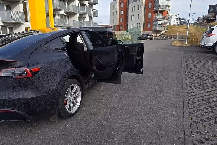 Sleek vehicle with open doors, set for a private transfer from Reykjavik to Blue Lagoon, highlighting convenience and luxury.
