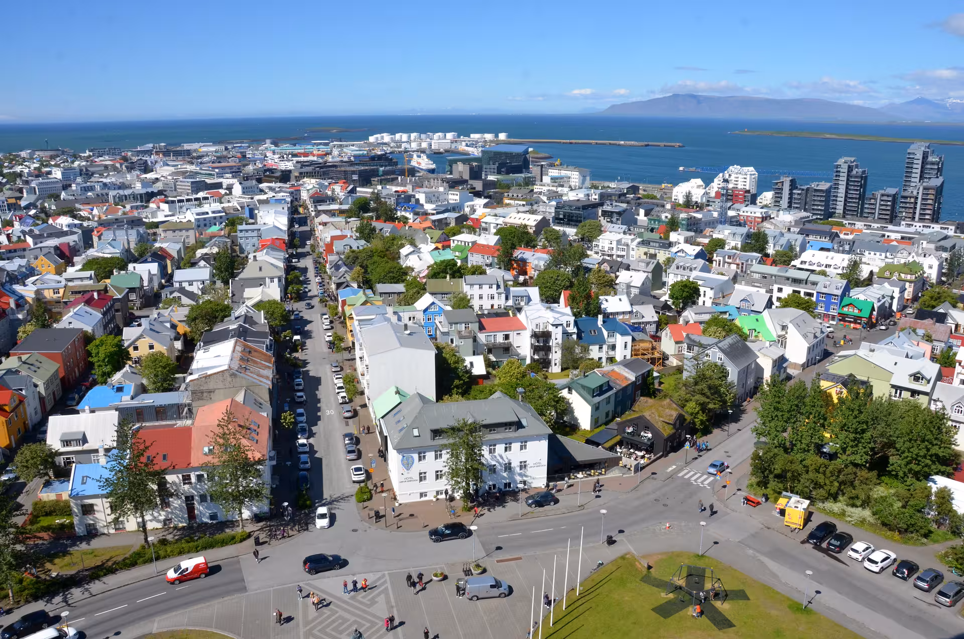 Aerial view of colorful Reykjavik city buildings and harbor with mountains in background
