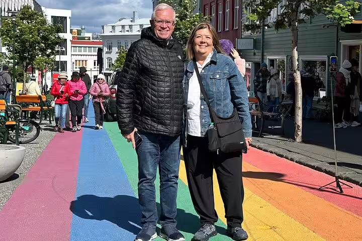 Couple standing on rainbow street in Reykjavik Iceland city center
