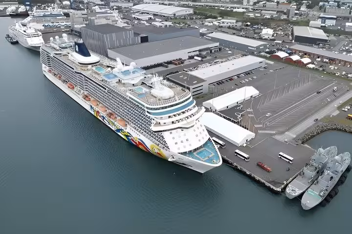 Aerial view of large Norwegian cruise ship docked at Reykjavik cruise port terminal with industrial buildings