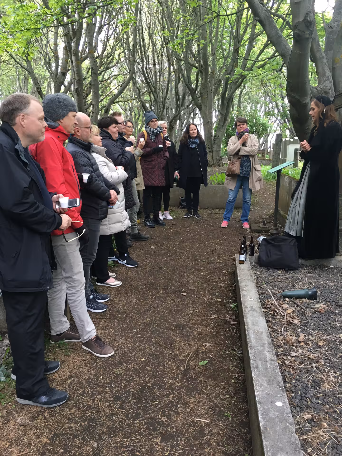 Tour group listening to a guide in a wooded area in Reykjavík, enjoying traditional tastes.