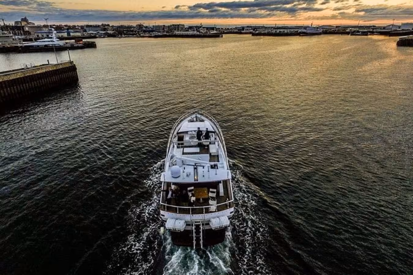 Aerial view of luxury yacht sailing Reykjavik harbor at sunset during evening boat tour