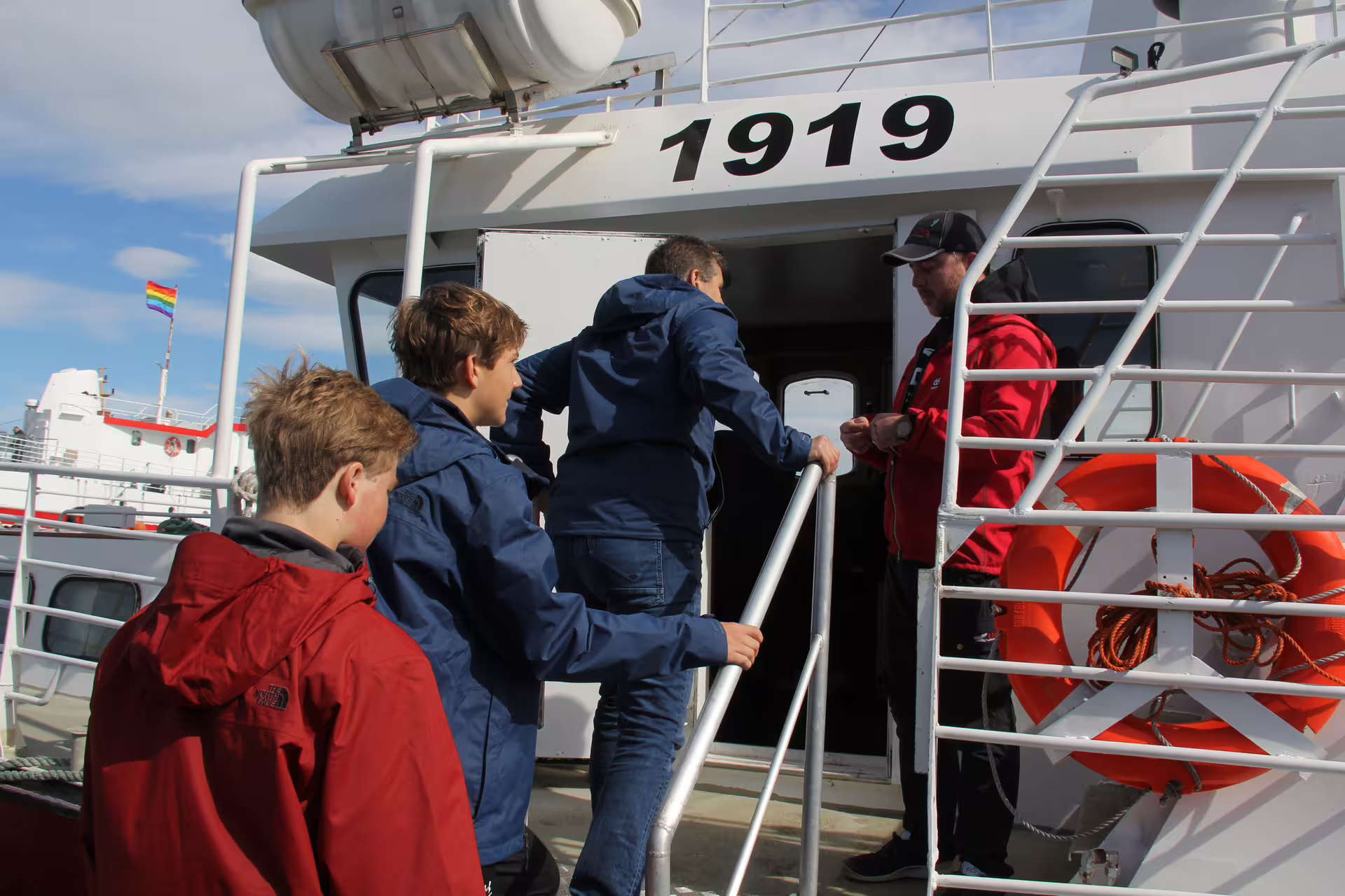 Kids boarding ferry boat 1919 with crew member at Reykjavik Skarfabakki harbor
