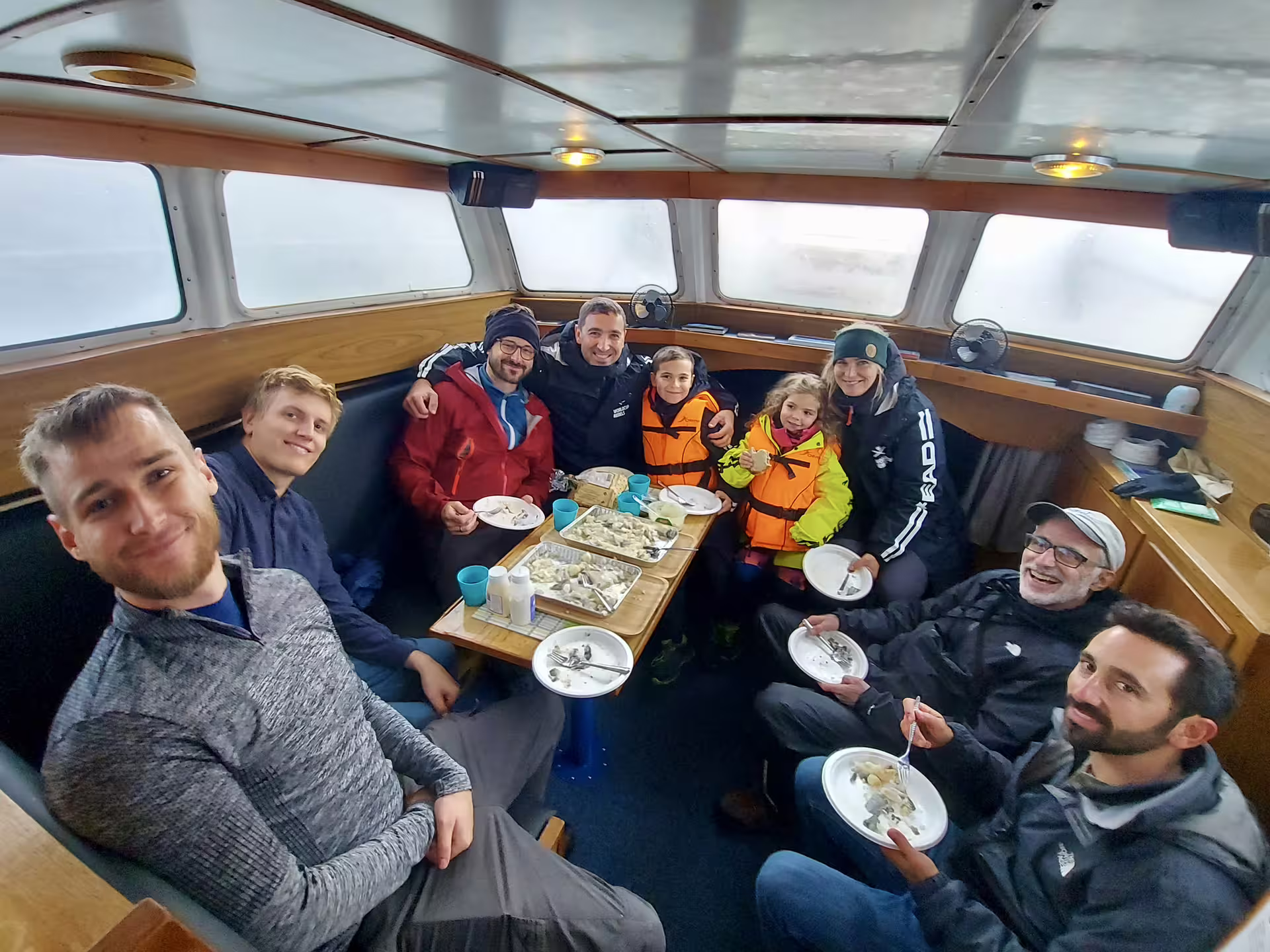 Group of tourists dining on fresh catch aboard a Reykjavik fishing boat tour