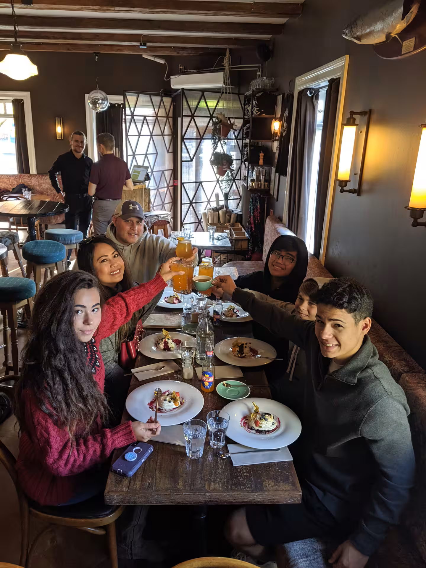 Group of friends toasting drinks over Icelandic food at a cozy Reykjavik restaurant during a food tour