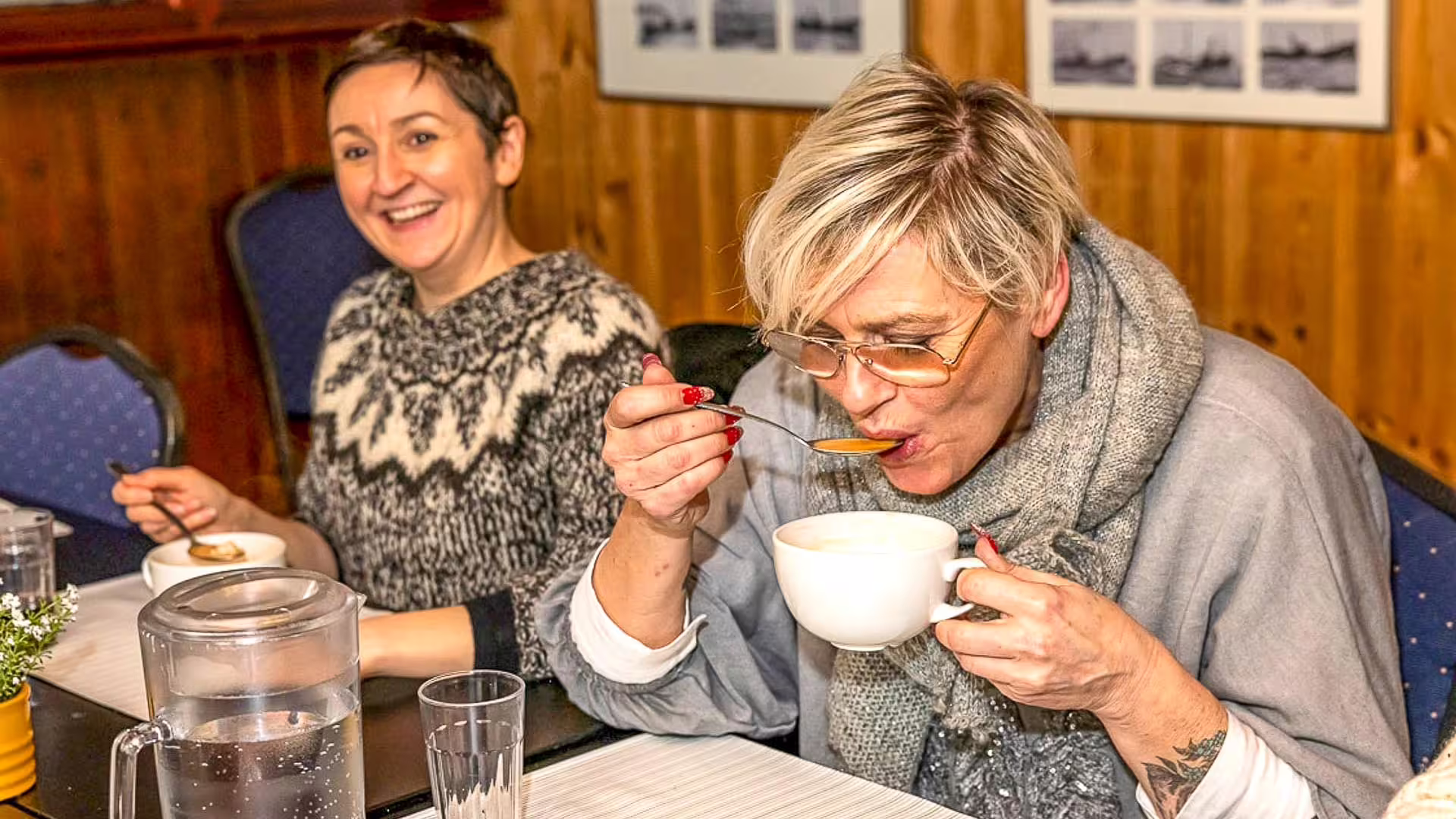 Two women enjoying soup at a cozy Reykjavik restaurant during a folklore and food walking tour