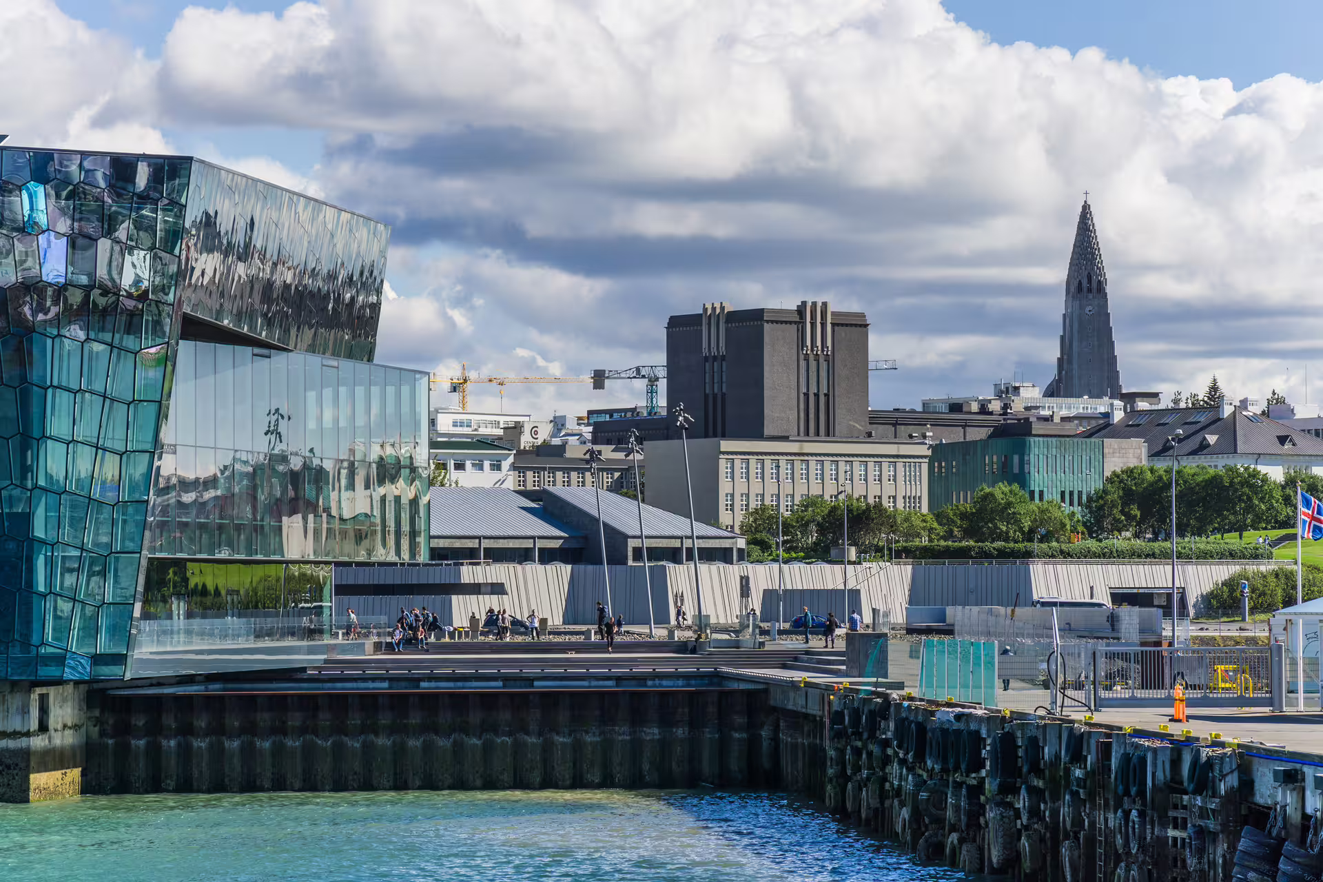 Harpa Concert Hall and Hallgrímskirkja church tower along Reykjavik harbor waterfront