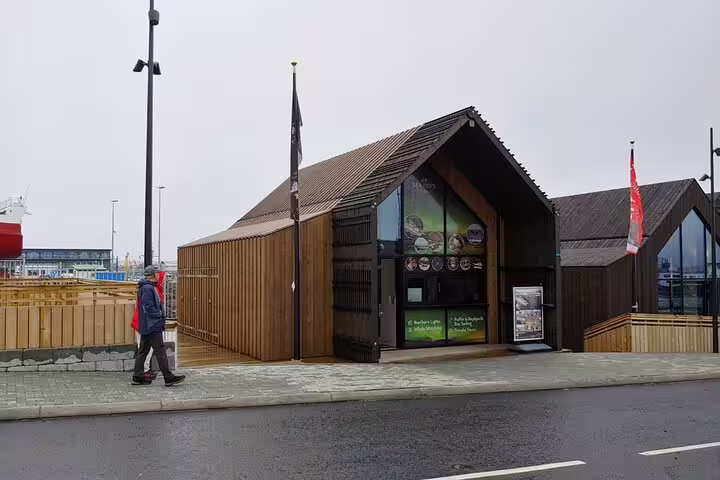 Wooden tour operator kiosk at Reykjavik harbor offering puffin and whale watching tours