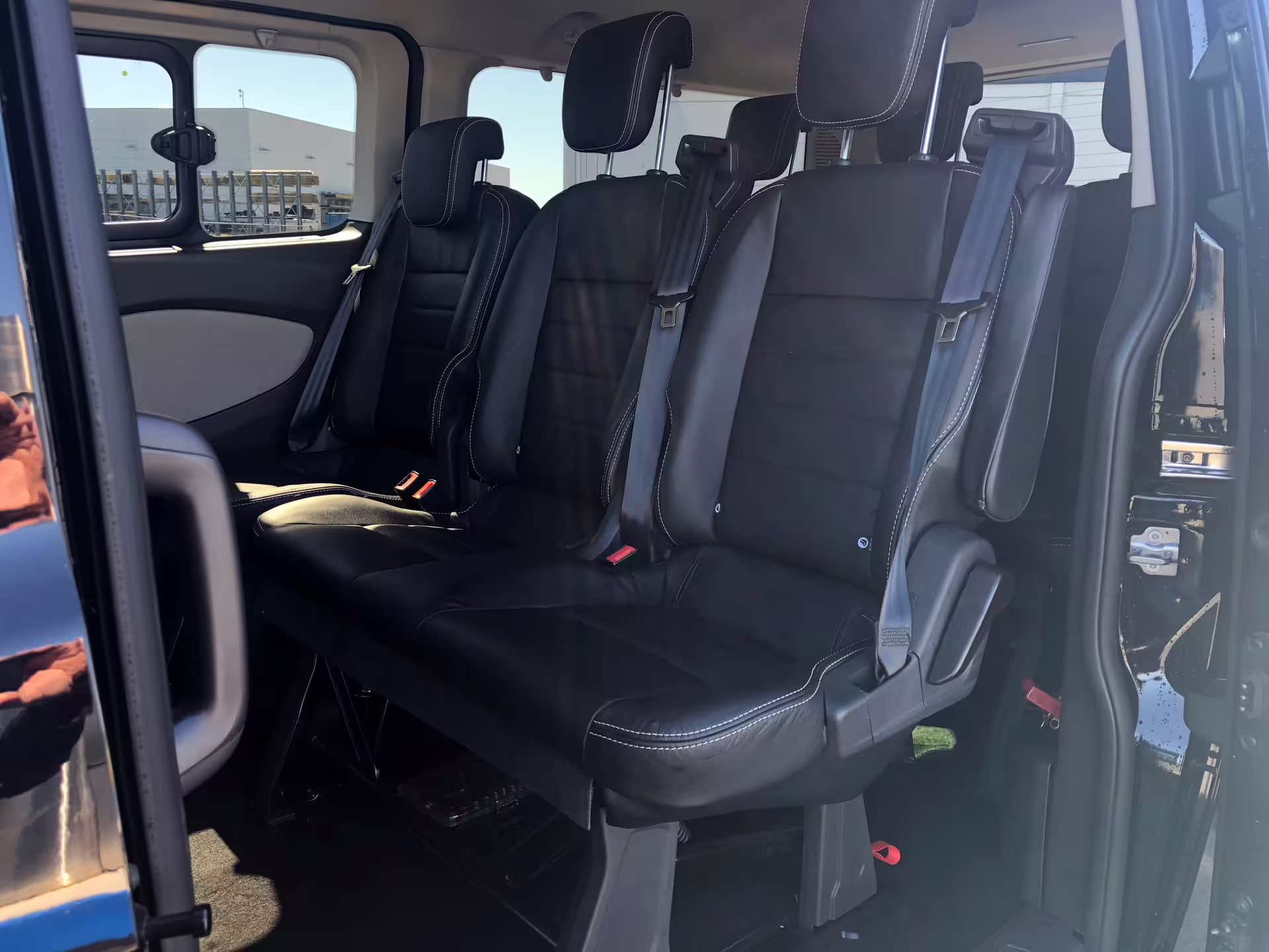 Black leather passenger seats inside Reykjavik hotel transfer minivan with seatbelts