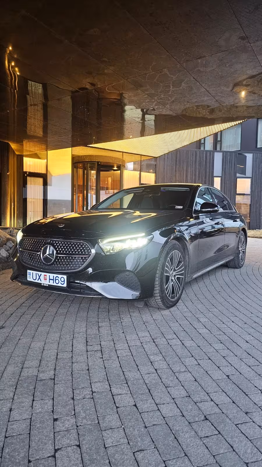 Luxury black Mercedes sedan parked at a hotel entrance for private Reykjavik to Keflavik Airport transfer service