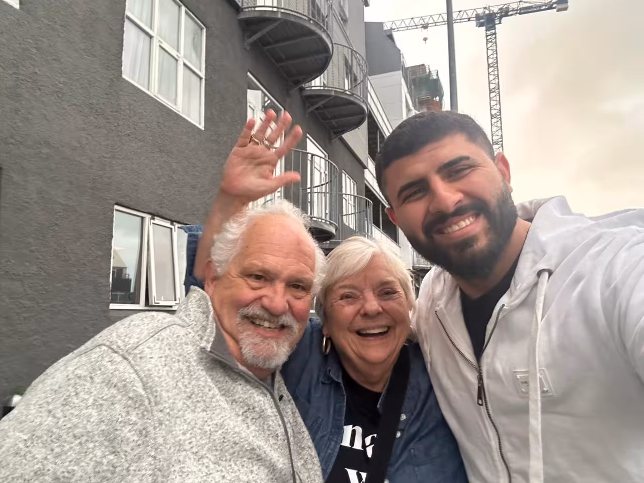 Happy travelers taking a selfie with a local guide outside an apartment building in Reykjavik