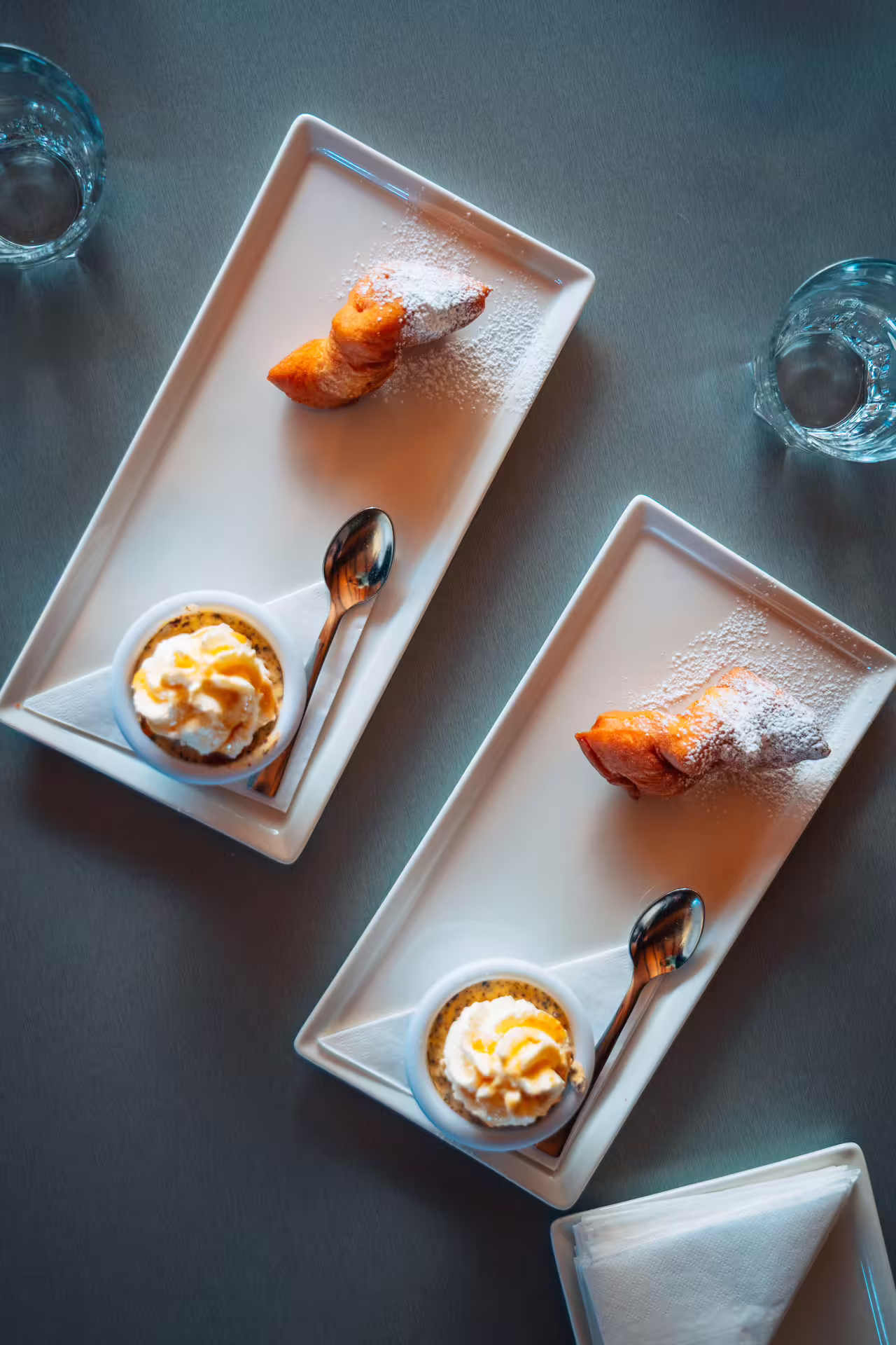 Two elegant dessert plates with powdered sugar pastries and whipped cream crème brûlée at a Reykjavik food tour