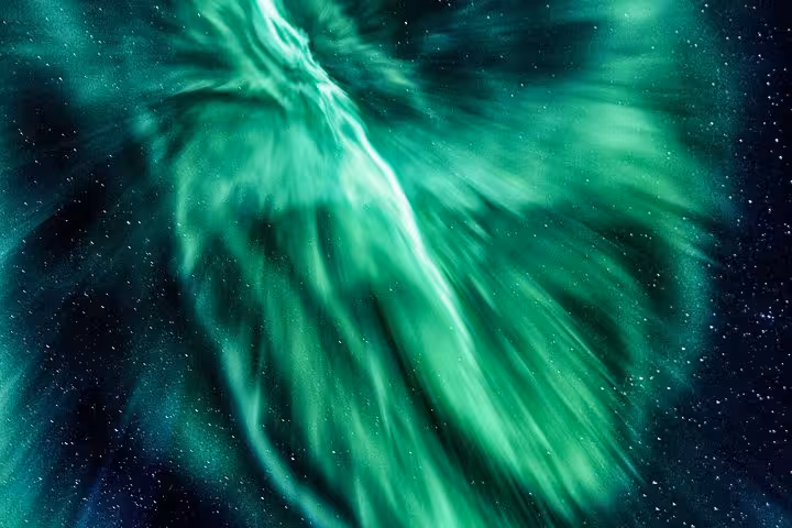 Vibrant green northern lights swirling dramatically across a starry night sky in Reykjavik