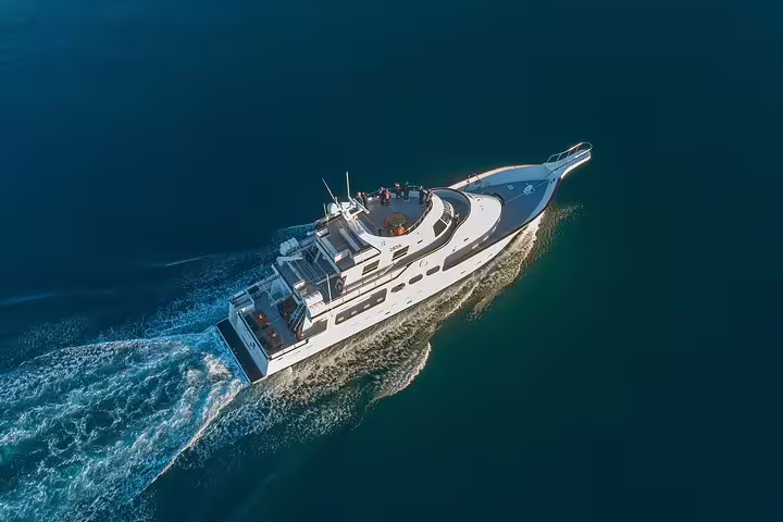 Aerial view of a white yacht cruising through deep blue waters on a Northern Lights boat tour in Reykjavik