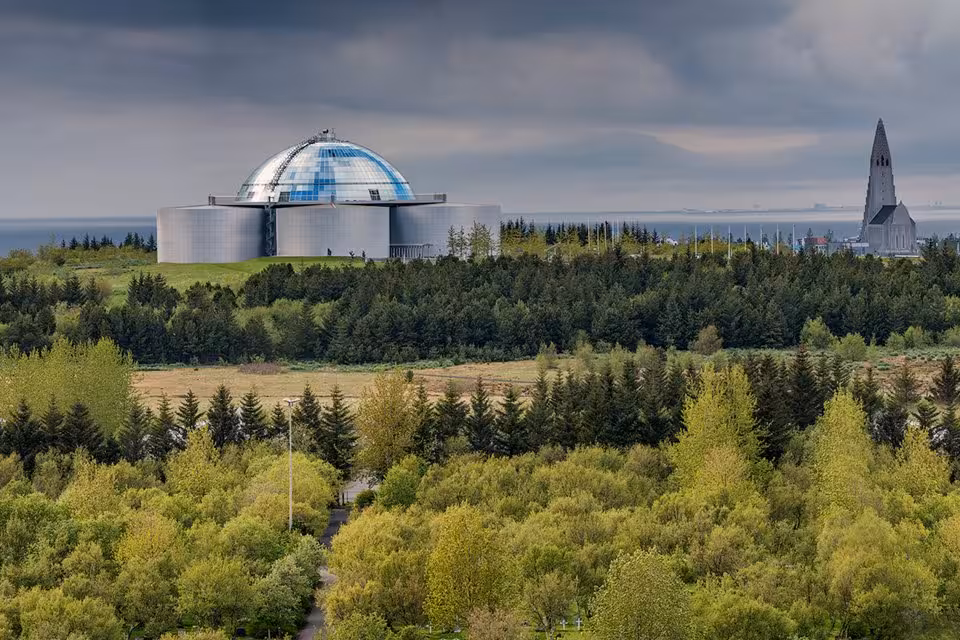 Perlan dome and Hallgrimskirkja church rising above Reykjavik green forest on a private sightseeing tour