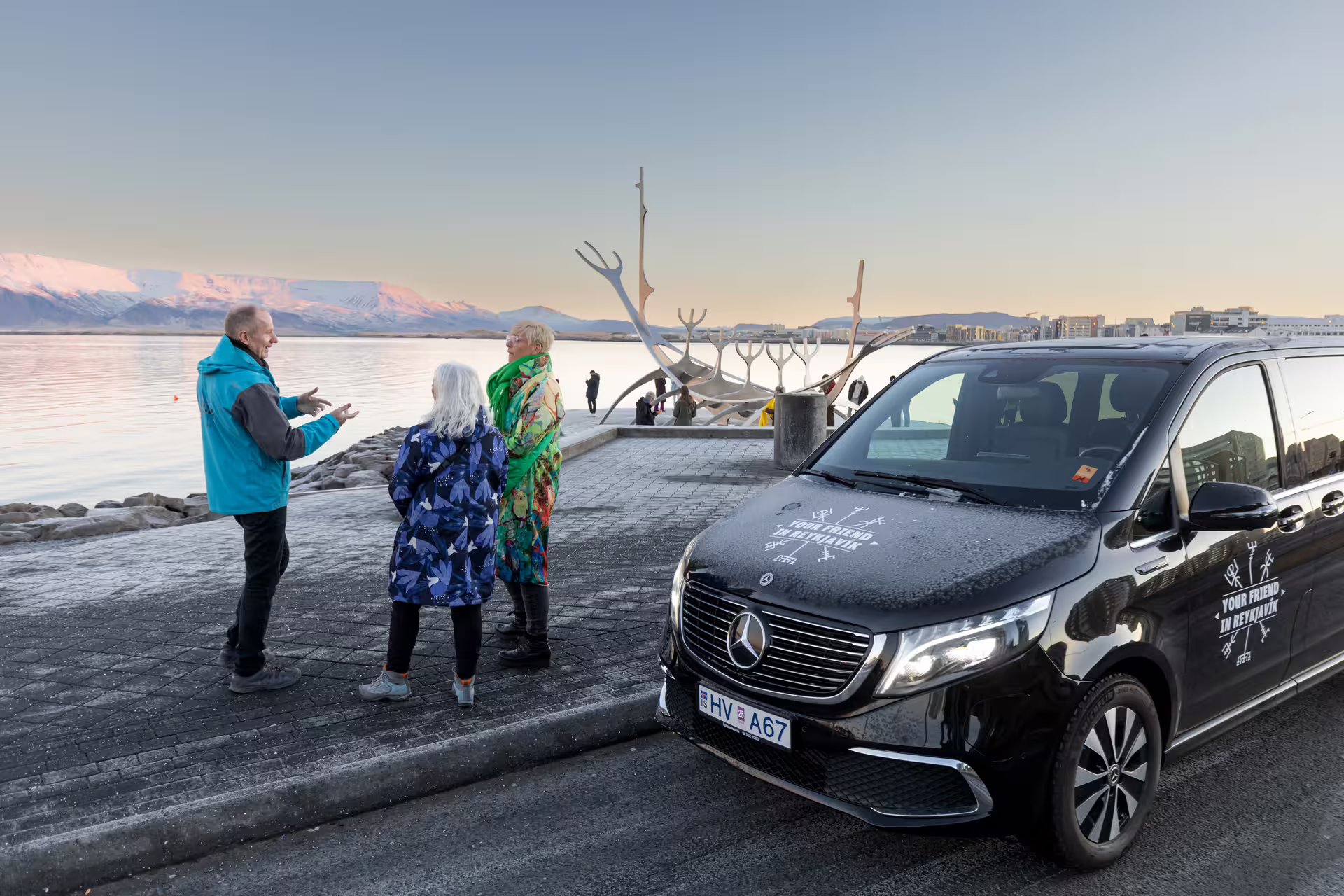 A group of travellers next to a tour vehicle from Your Friend in Reykjavik