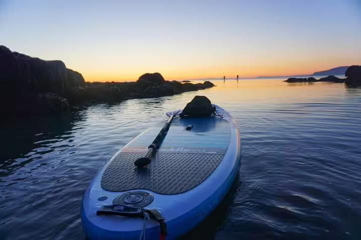 Serene Reykjavik sunset paddle board tour showcasing calm waters, vibrant horizon, and tranquil Icelandic landscape.