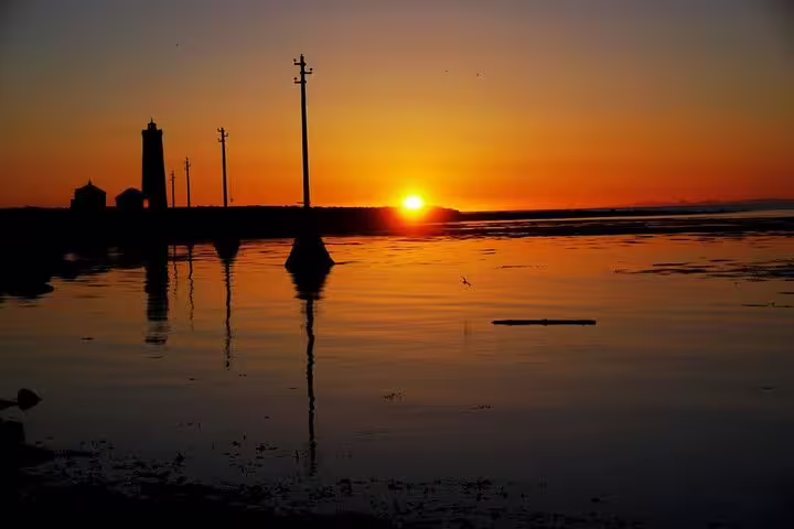 A person paddle boarding on calm waters during a stunning Reykjavik sunset, showcasing the serene beauty of Iceland's coastal landscape.