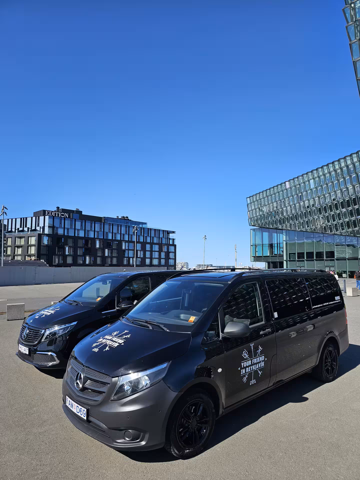 Two Tour Vehicles from Your Friend in Reykjavik parked in front of the Harpa Concert Hall in Reykjavik
