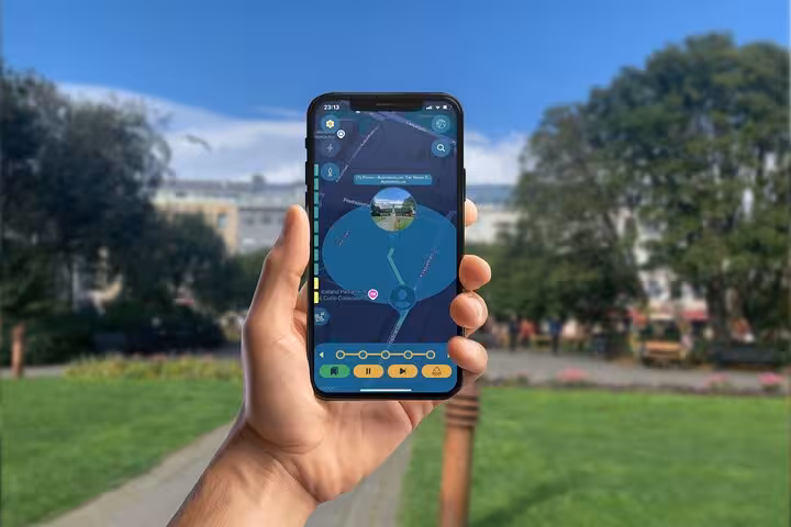 Hand holding smartphone displaying Viking walking tour app map in Reykjavik park