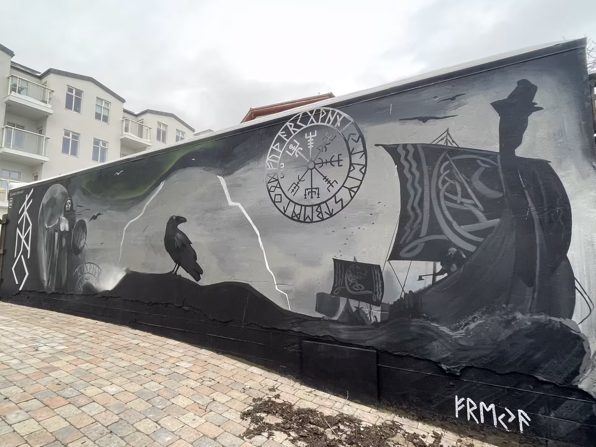 Viking Norse mythology mural with vegvisir compass, raven, and longship on Reykjavik wall