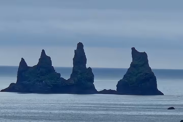 Reynisdrangar black volcanic sea stacks rising from the ocean on Iceland's South Coast