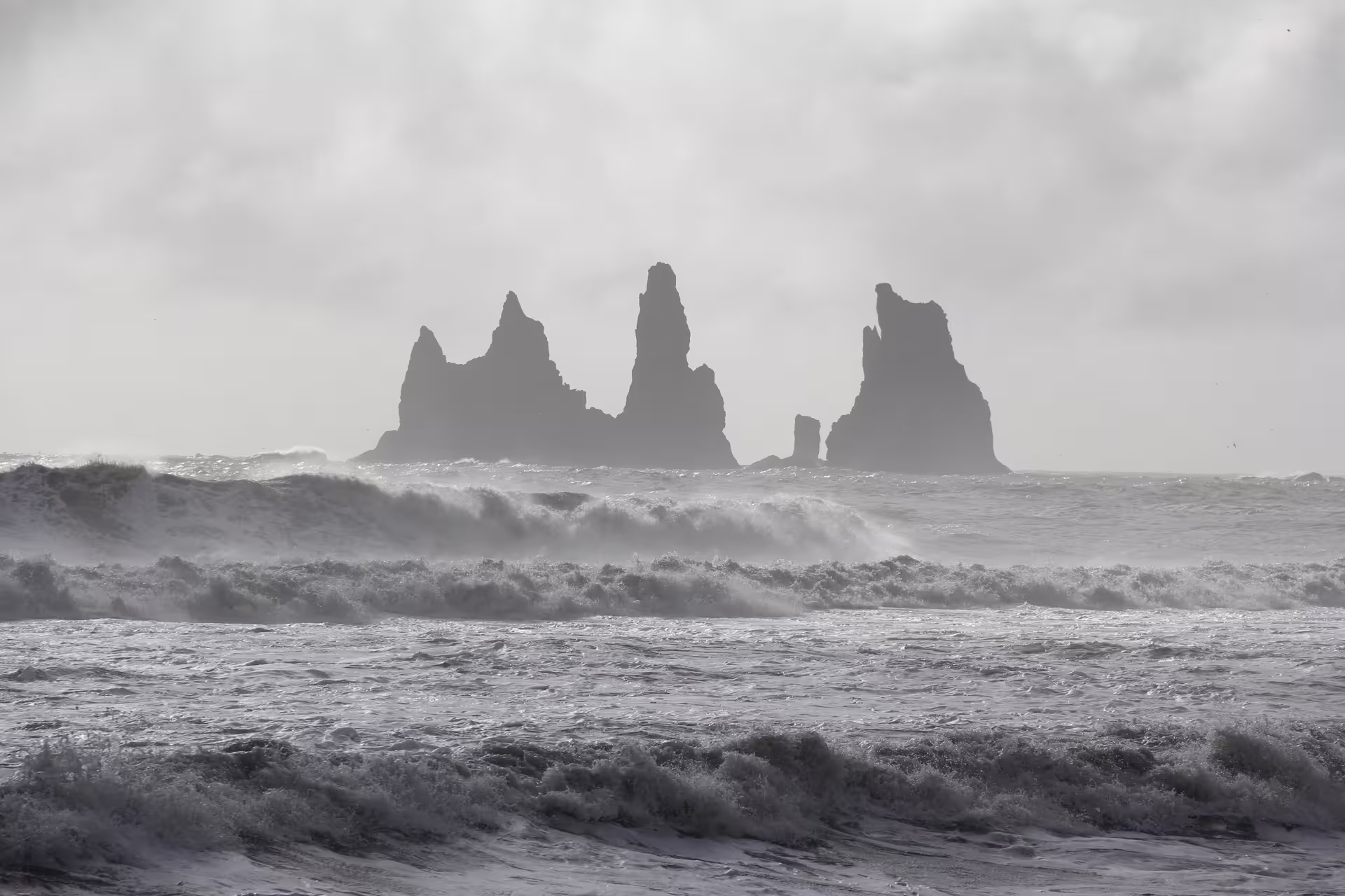 Dramatic Reynisdrangar sea stacks rise from stormy Atlantic waves on Iceland's South Coast