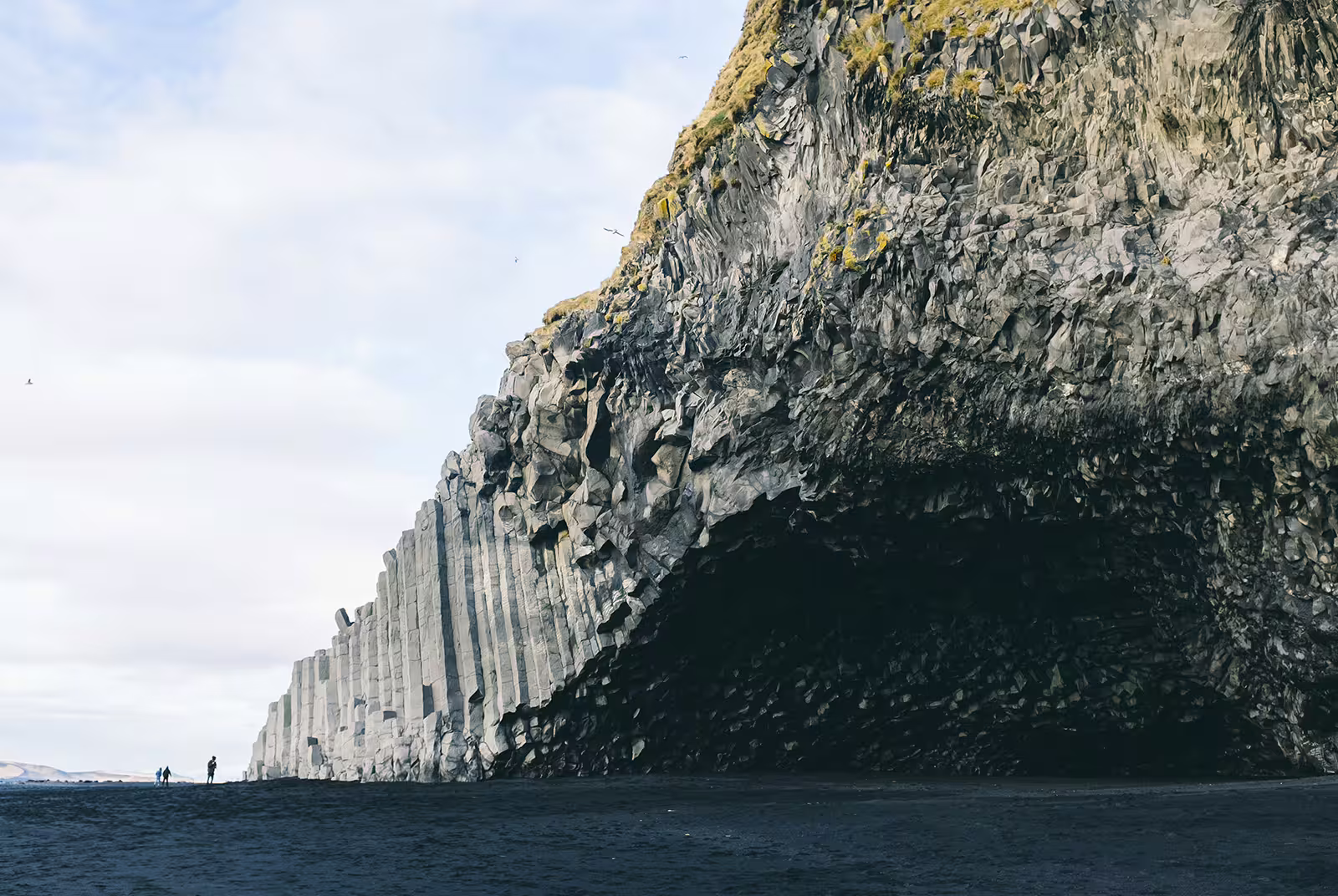 Basalt column cliffs and sea cave at Reynisfjara black sand beach on Iceland's south coast