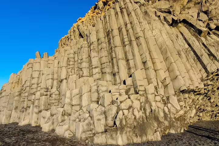 Towering basalt column rock formations at Reynisfjara black sand beach on Iceland South Coast tour