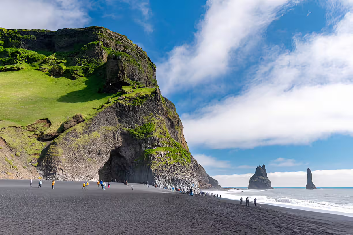 Black sand beach Reynisfjara with volcanic cliffs and sea stacks on Iceland South Coast