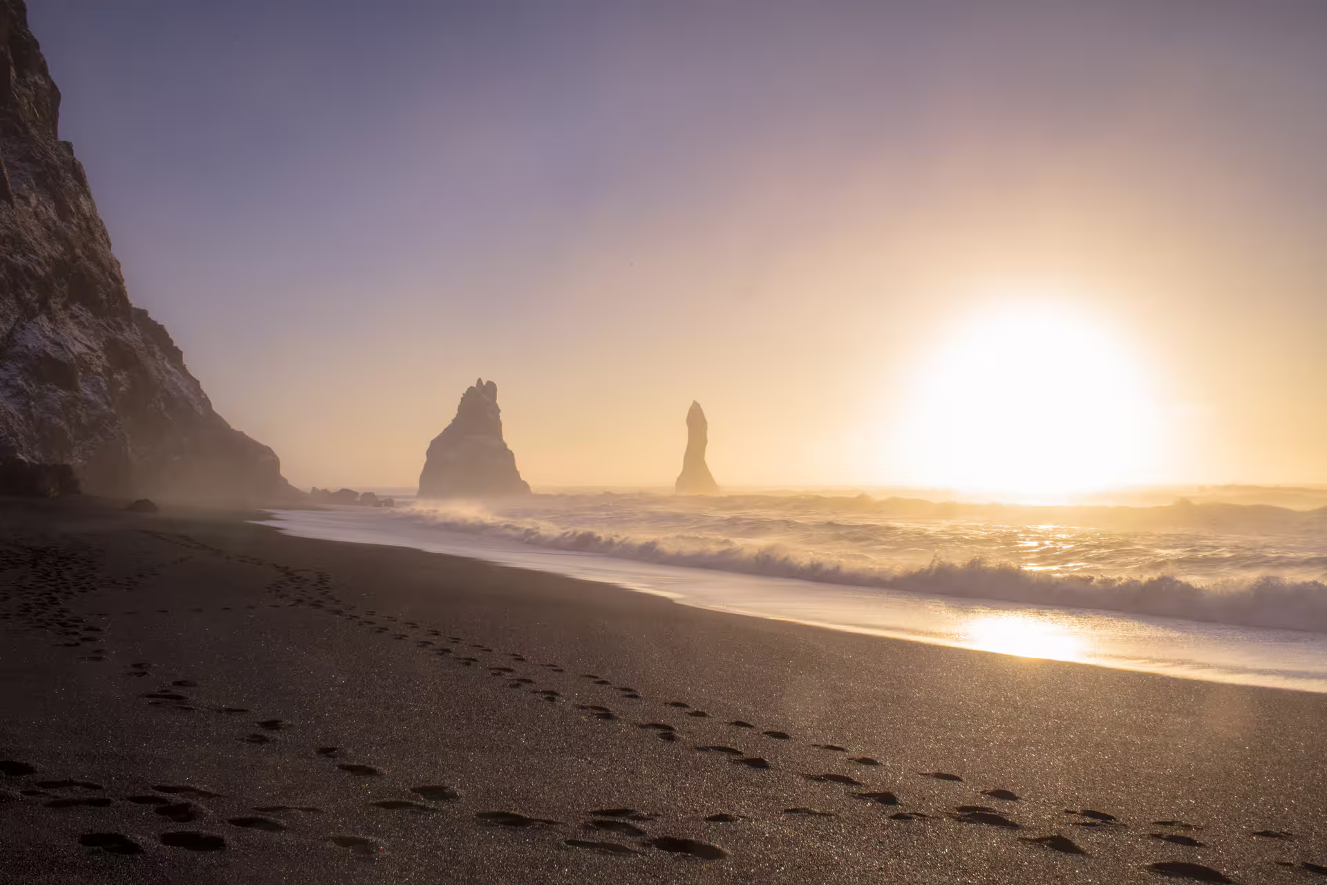 Black sand beach with dramatic sea stacks at golden sunset, Reynisfjara Iceland South Coast