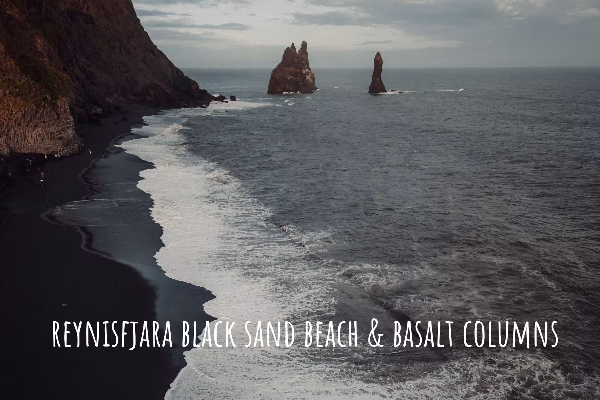 Reynisfjara black sand beach with basalt columns and sea stacks in South Iceland