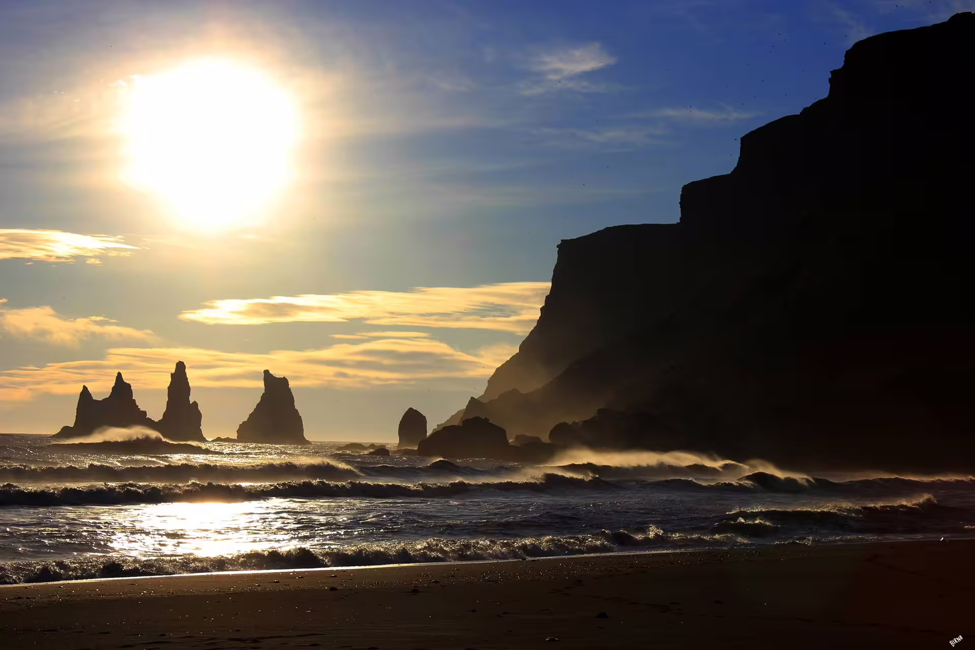 Dramatic Reynisfjara black sand beach sunset with sea stacks, a breathtaking destination on a custom private SUV tour