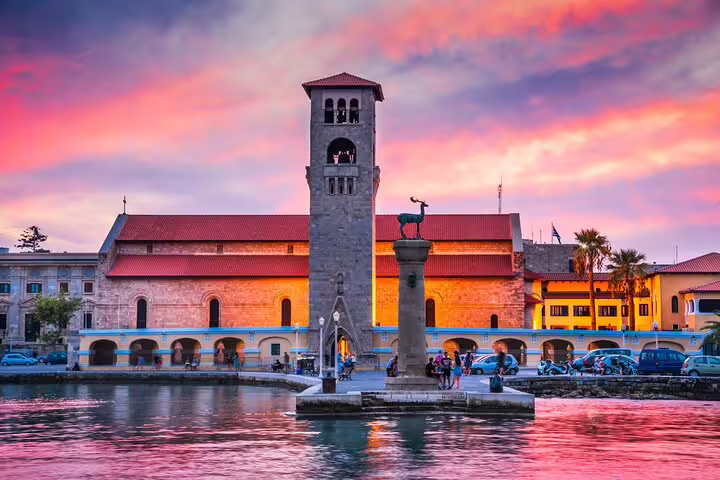 Vibrant sunset over Rhodes Old Town harbor, highlighting historical architecture and local charm for night ride experience.