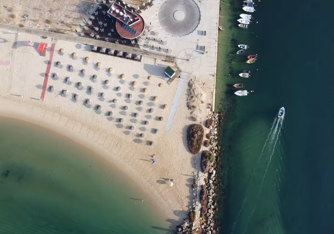 Aerial top-down view of Algarve beach marina with boats departing for Ria Formosa Armona Island tour