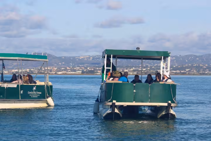 Passengers on a Ria Formosa boat tour from Faro cruising the lagoon toward two island stops in Algarve, Portugal