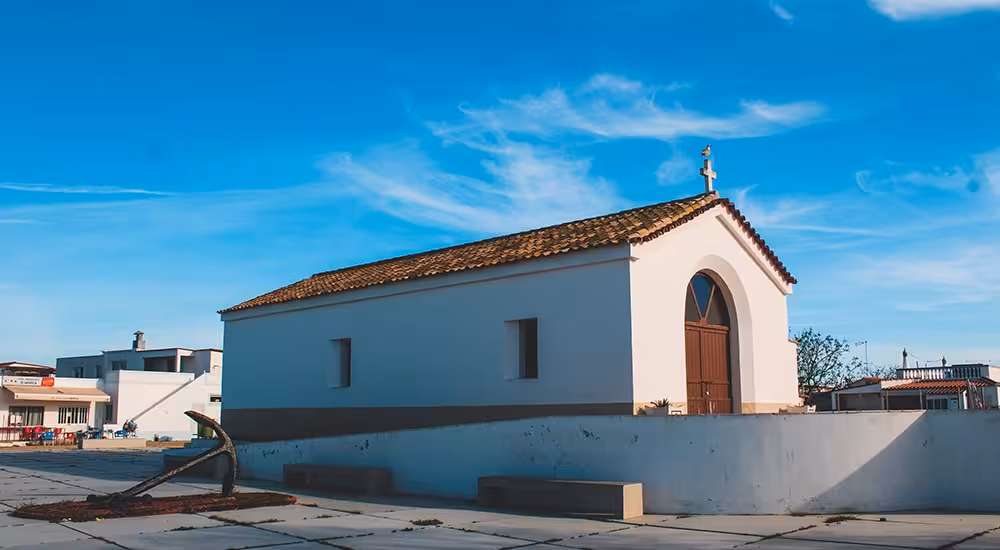 White chapel with terracotta roof and anchor on Ria Formosa island stop during Olhao boat tour Algarve