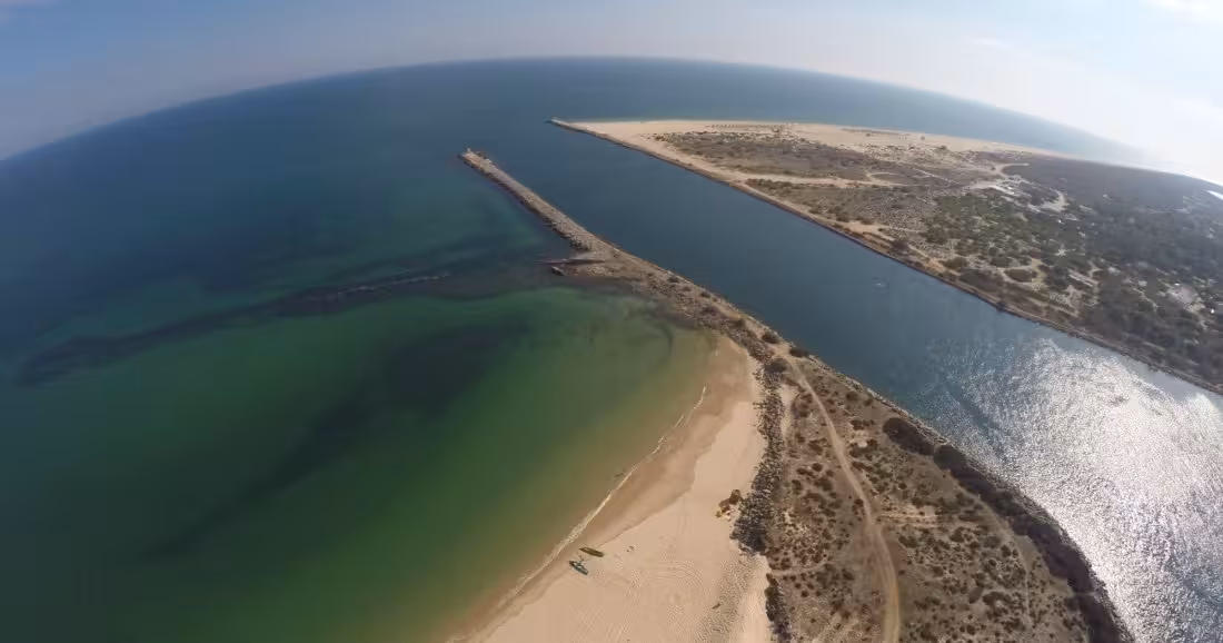 Aerial drone view of Ria Formosa sandy barrier islands and sparkling green waters on a Tavira boat tour Algarve