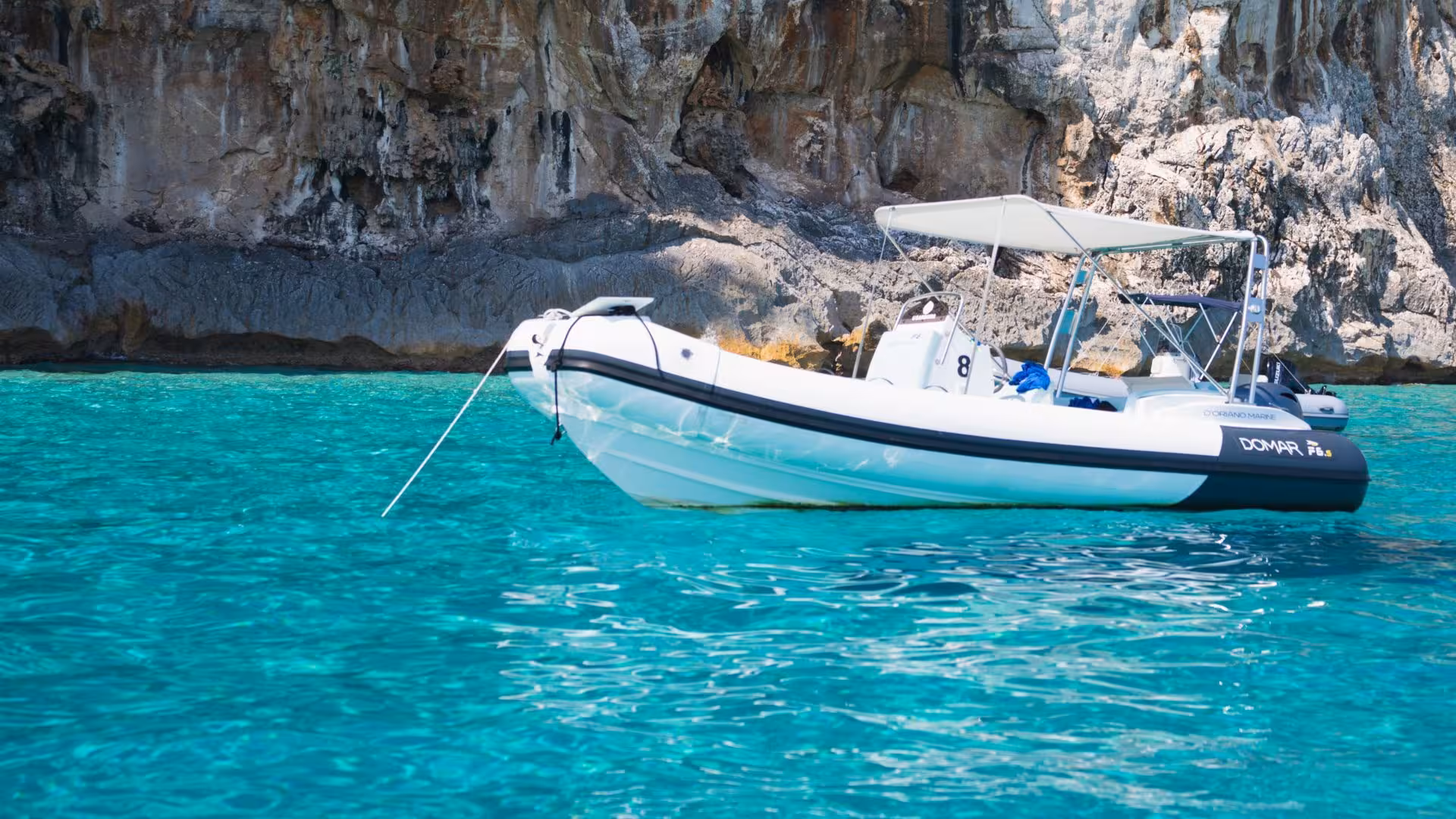 A sleek RIB boat floating on the crystal-clear waters near Cala Goloritzè, perfect for exploring Sardinia's coastline.