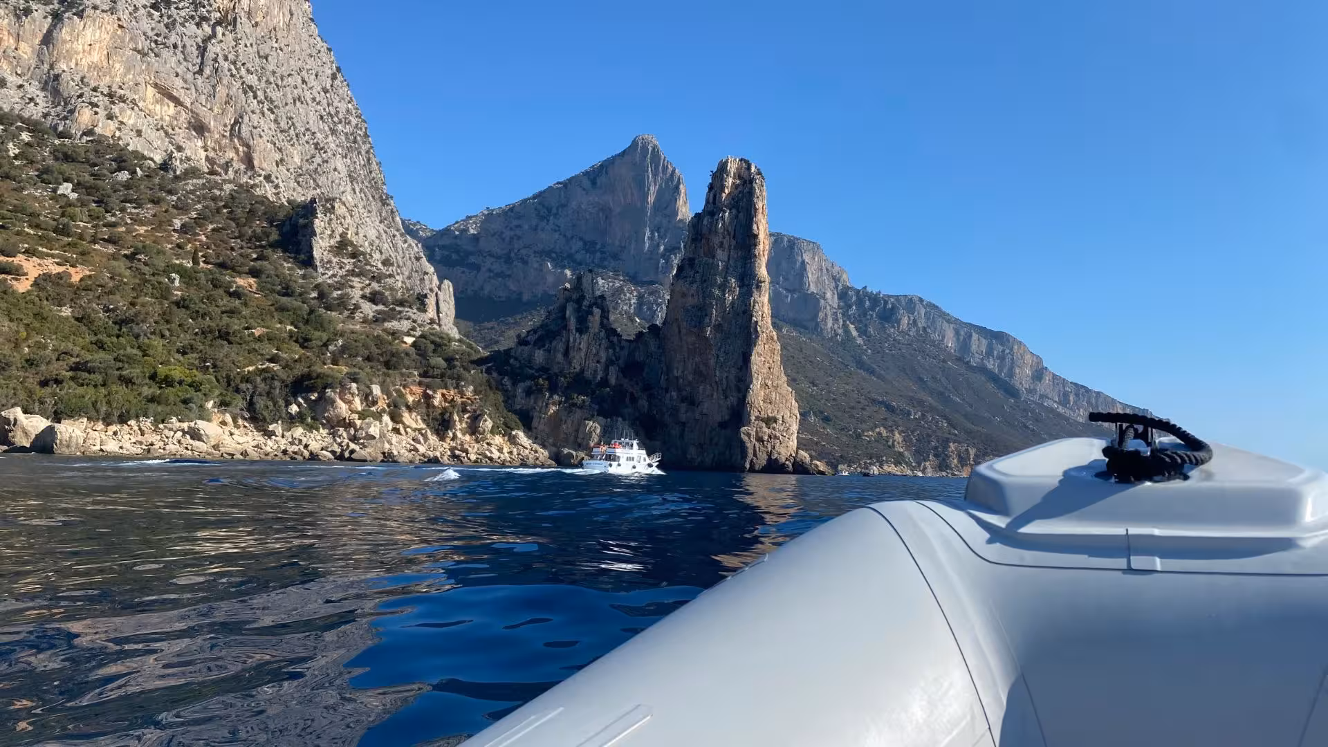 Breathtaking view of towering rock formations near Cala Goloritzè seen from a RIB boat on a clear day.