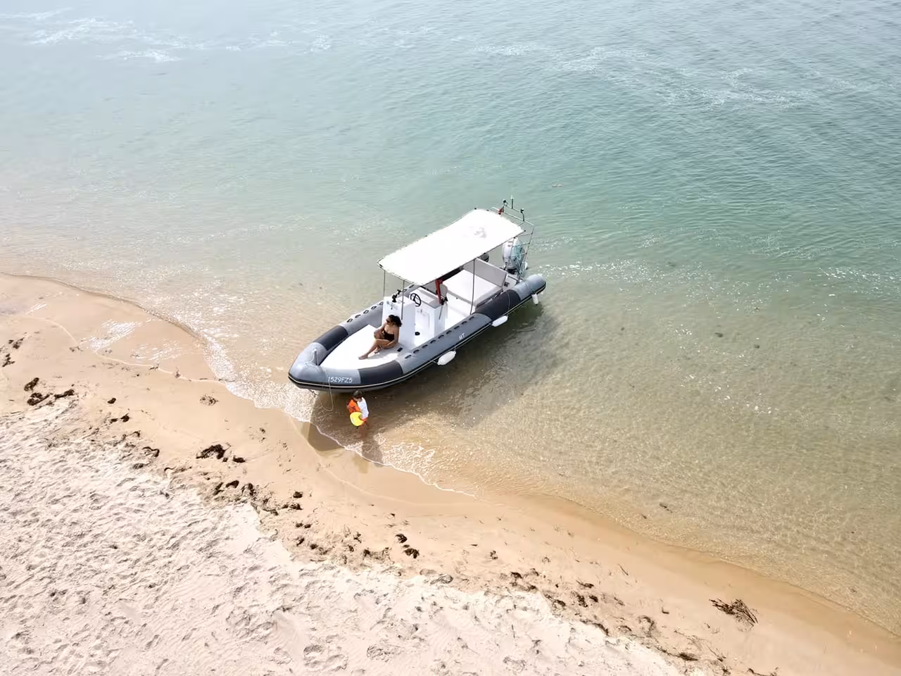 Aerial view of a RIB boat docked on a sandy shore during a Culatra Island boat tour from Olhao and Faro