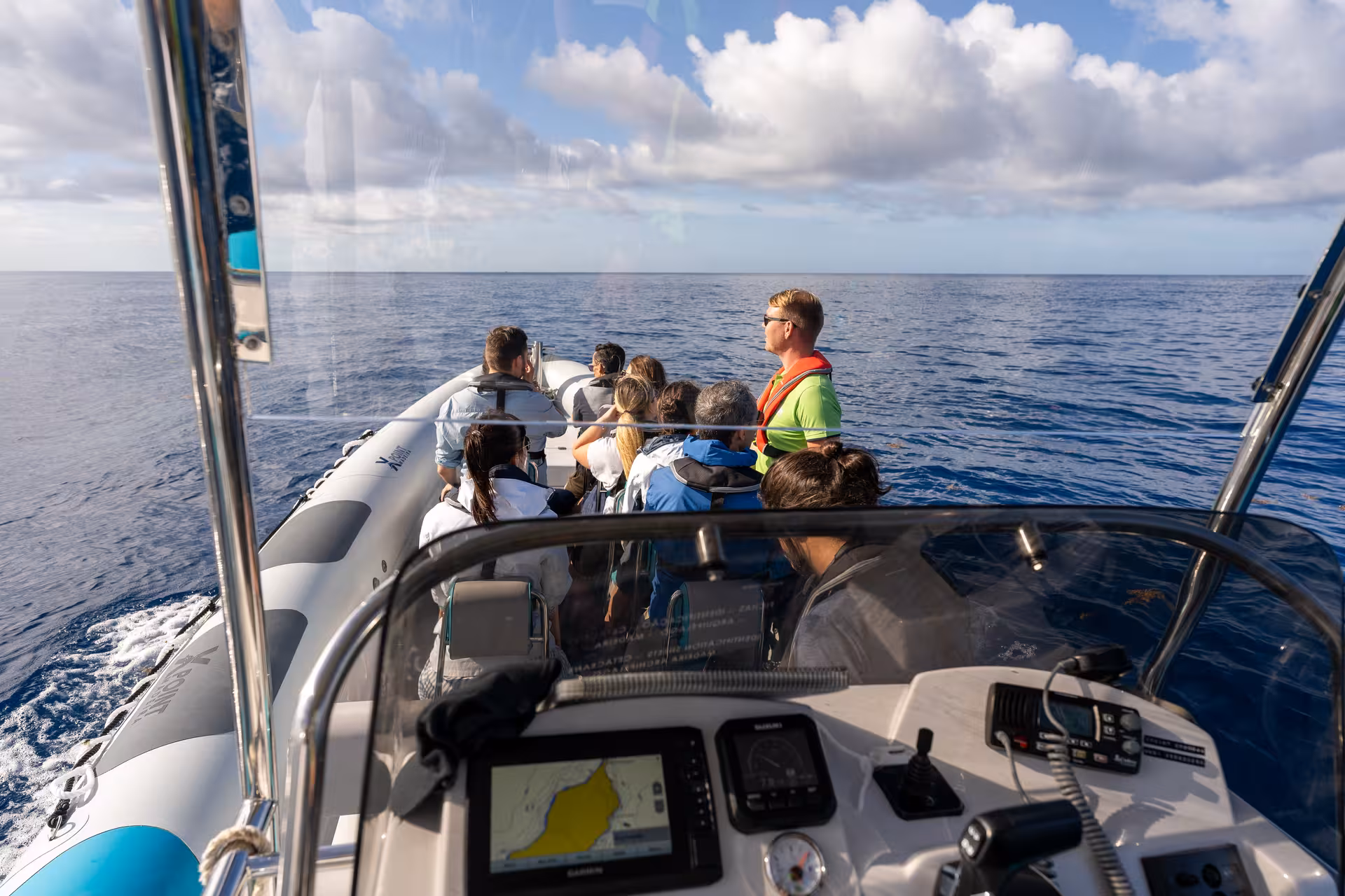 Tourists enjoy a guided RIB boat tour on the open sea, perfect for dolphin and whale watching adventures.