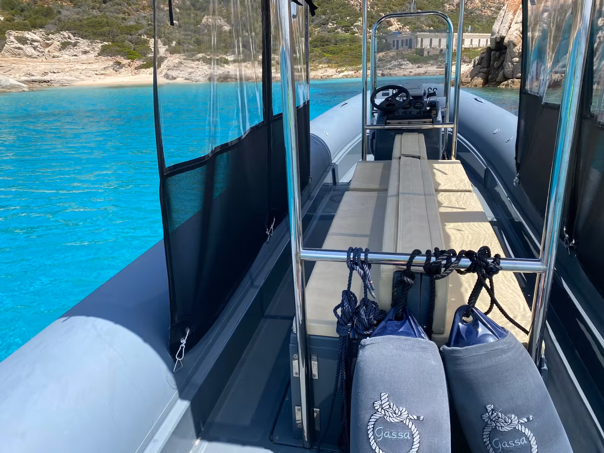 RIB boat anchored in the turquoise waters of La Maddalena Archipelago, offering a scenic tour experience.
