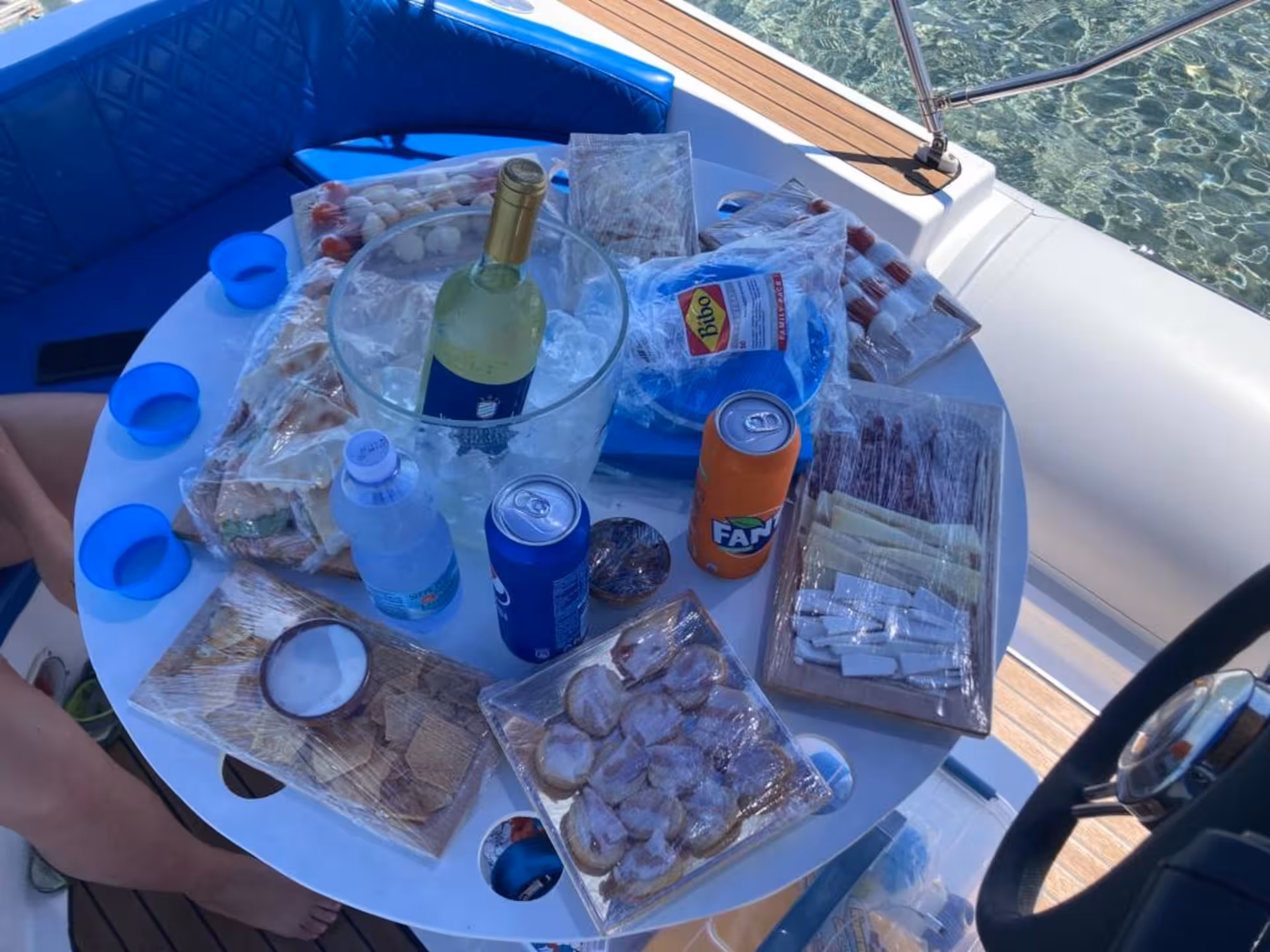 Assorted snacks and drinks on a RIB boat table, perfect for a scenic tour around Carloforte and Masua.
