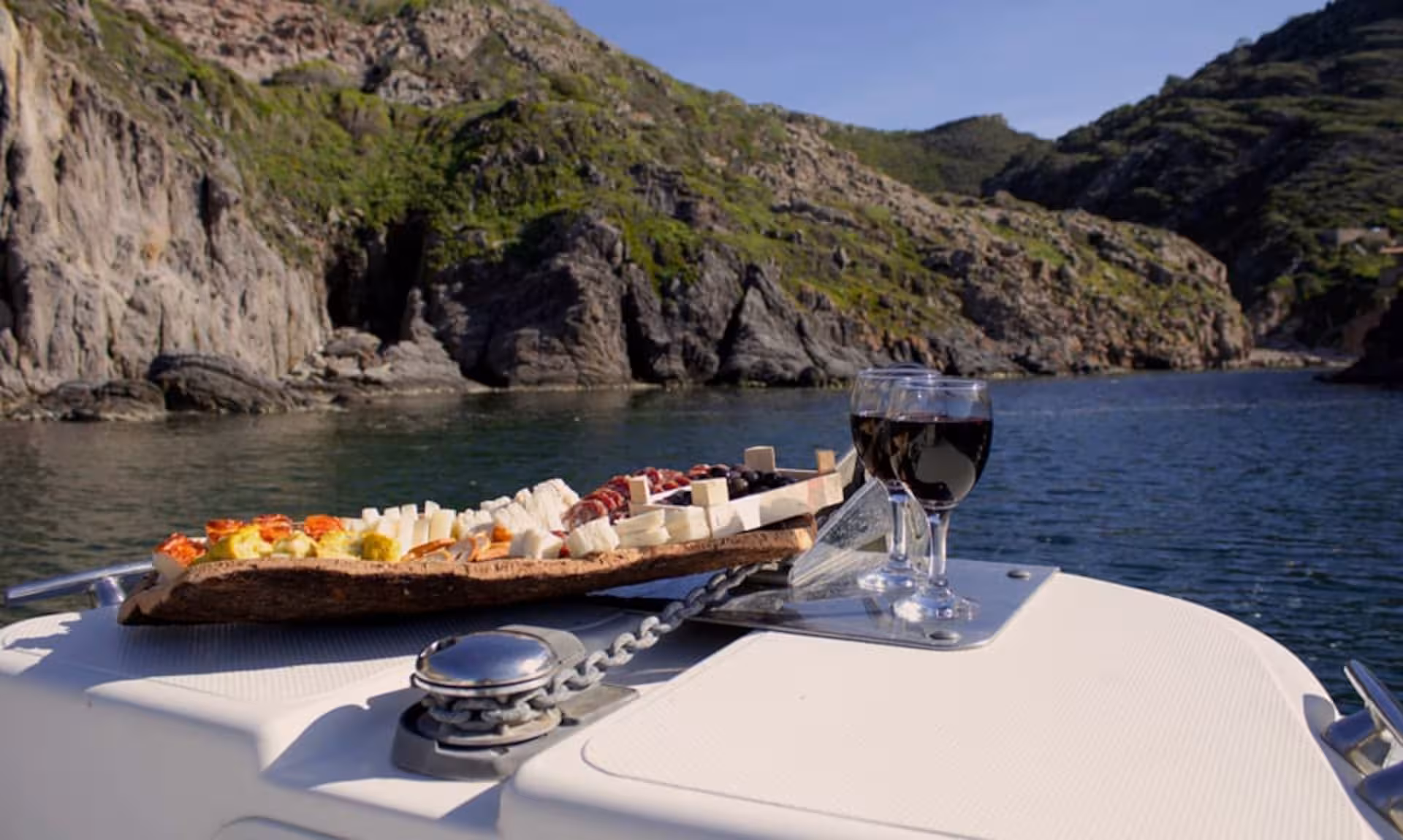 Gourmet platter with cheese and wine on a RIB boat tour between Carloforte and Masua, Sant'Antioco.
